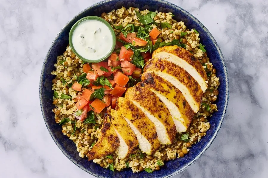 Grilled spiced chicken over bulgur and lentils with tomato salad and a yogurt sauce